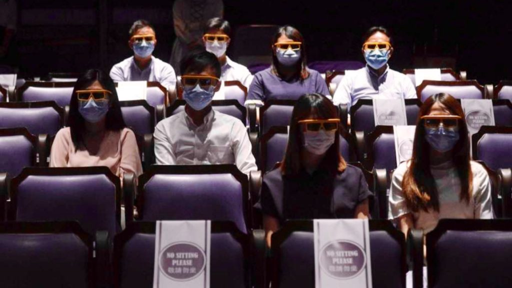 Watching movie at movie theaters with face masks and 3D glasses. Picture: Photo: Kin Cheung, AP